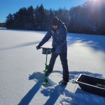 Field ecologist Aaron Schoofs checks the ice depth at Crampton Lake (CRAM). Photo credit: Jill Pyatt