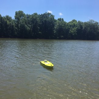 Staff deploy remote controlled ARC-Boats at river sites while standing on the floodplain. This boat holds an ADCP inside of it and is driven back and forth across the channel to measure discharge.