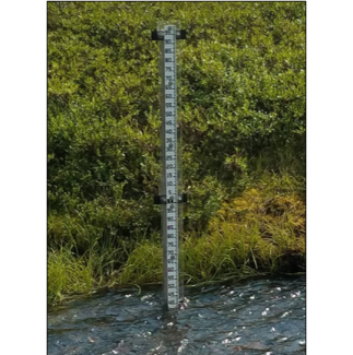 A staff gauge installed at a NEON aquatic site where water level is measured.