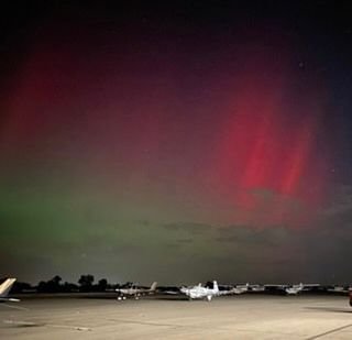 Northern lights over an airfield and plane
