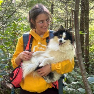 A field tech holds a small dog