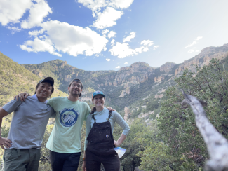Dr. Suzuki and lab members in front of mountains