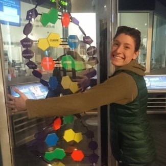 Danielle Blumstein hugging a model of DNA