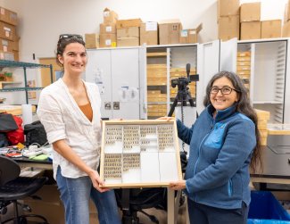 Alyson East and Sydne Record holding a beetle collection tray