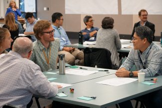 Reid Longley sitting at a table at NEON Convergence Summit