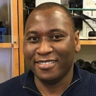 Israel Borokini smiling at camera in an office.