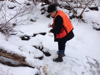 Field technician sampling in the snow